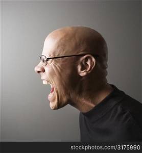 Profile portrait of mid-adult Caucasian male screaming.