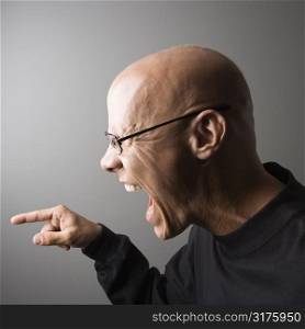 Profile portrait of mid-adult Caucasian male screaming and pointing.