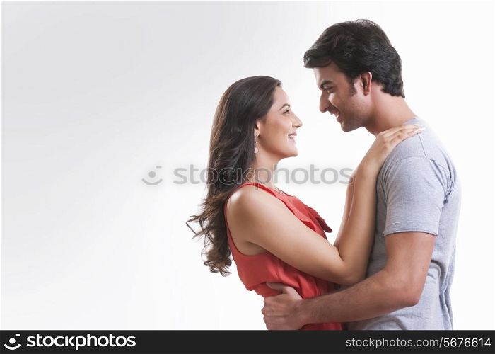 Profile shot of affectionate young couple looking at each other against white background