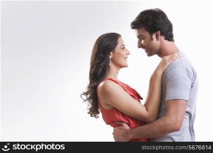 Profile shot of affectionate young couple looking at each other against white background