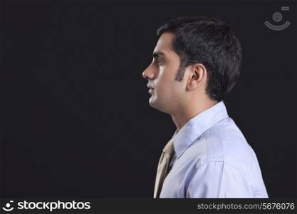 Profile shot of businessman against black background