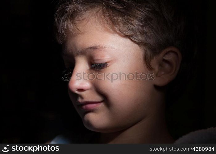 profile shot of the boy in the dark, focused light on the one side