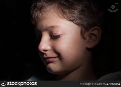 profile shot of the boy in the dark, focused light on the one side