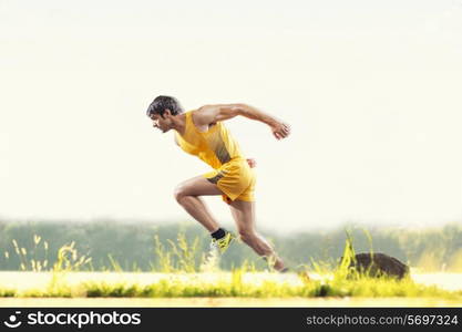 Profile shot of young male runner running outdoors