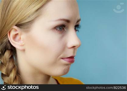 Profile side view portrait of young woman having blonde hair braid hairstyle.. Half woman face with braid hair