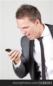 Profile view of a young business man screaming in his cellphone over white