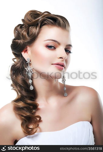 Profile view of beautiful bride dressed in white dress. Festive coiffure and makeup