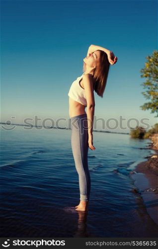 Profile view of the beautiful young girl in the morning in the water