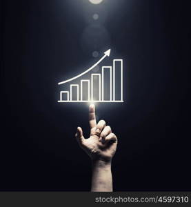 Profit chart. Human hand pointing with finger at growing graph