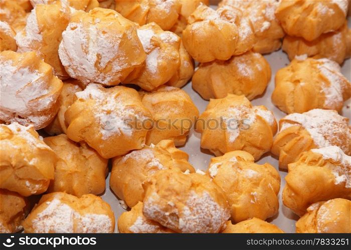 profiteroles choux pastry buns with whipped cream as background
