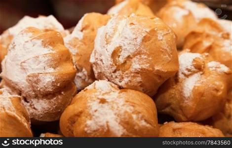 profiteroles choux pastry buns with whipped cream as background
