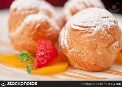 profiteroles. profiteroles from cream and condensed milk decorated with strawberry and peach