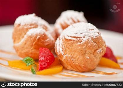 profiteroles. profiteroles from cream and condensed milk decorated with strawberry and peach