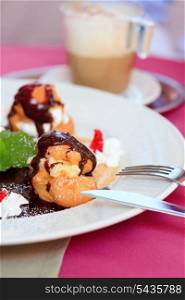 profiteroles with chocolate on plate