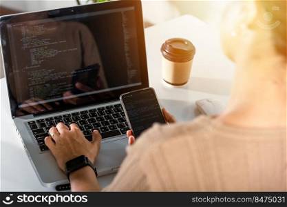 Programmer woman looking mobile phone program code at workplace, software developer hands typing data coding programming javascript with laptop computer, IT startup concept, Web application design