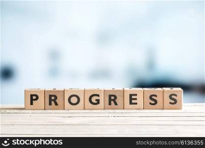 Progress word spelled with wooden cubes on a desk