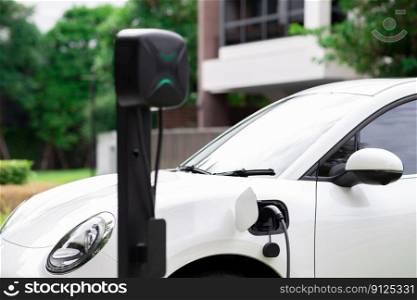 Progressive concept of EV car and home charging station powered by sustainable and clean energy with zero CO2 emission for green environmental. Charging point at residential area for electric vehicle.. Progressive concept of EV car and home charging station in residential area.