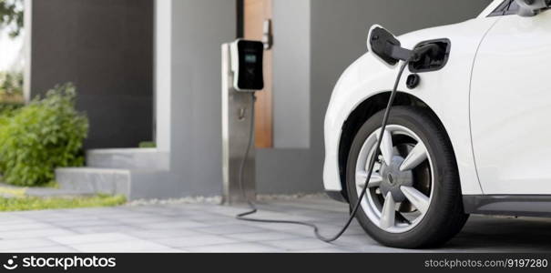 Progressive concept of EV car and home charging station powered by sustainable and clean energy with zero CO2 emission for green environmental. Charging point at residential area for electric vehicle.. Progressive concept of EV car and home charging station in residential area.