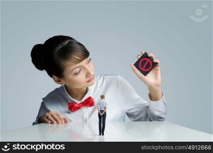 Prohibition concept. Young woman holding card with prohibition sign