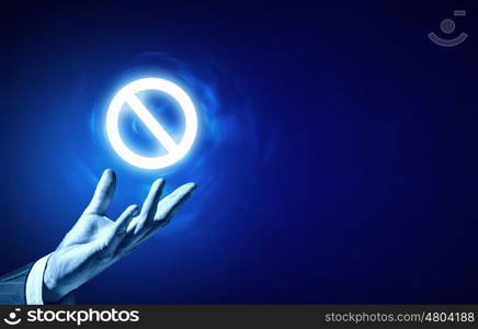 Prohibition icon. Person hand holding digital prohibition sign on blue background