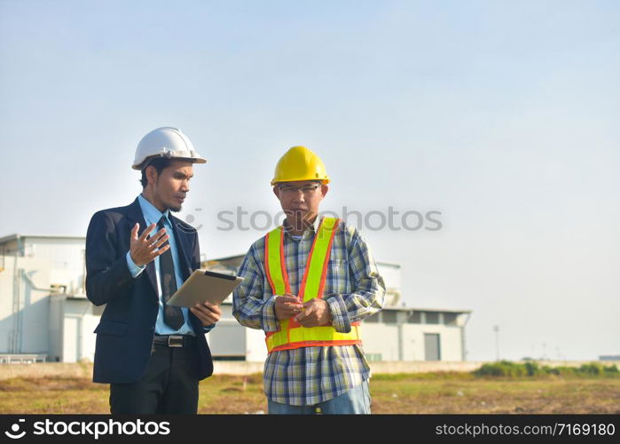 Project manager and Engineer communication use tablet factory background