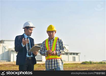 Project manager and Engineer communication use tablet factory background