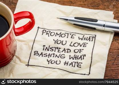 Promote what you love instead of bashing what you hate - handwriting on a napkin with cup of coffee