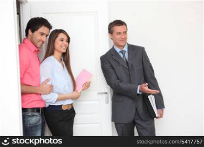 Promoter and young couple visiting a flat