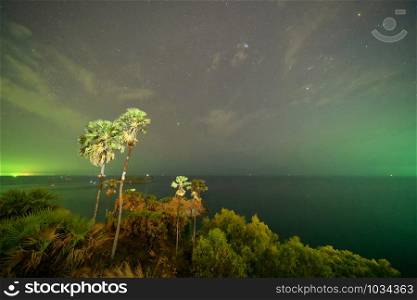 Promthep Cape viewpoint at night with stars and space in universe, Andaman sea in Phuket Island, tourist attraction in Thailand in travel trip and holidays vacation. Natural landscape background.