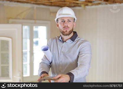 property developper on stepladder in house needing renovating