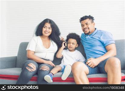 Prortrait of African black family sitting on sofa in cozy living room. House moving, Diversity and Black Live Matters Concept.