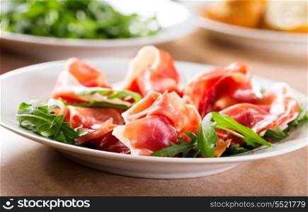 prosciutto ham with rucola on a plate