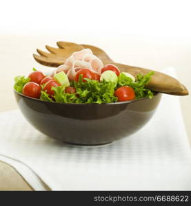 Prosciutto salad with wooden spoon on the table