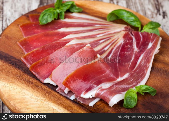 prosciutto. sliced prosciutto on a wooden table