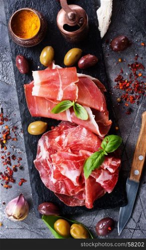 prosciutto with olives and spice on a table