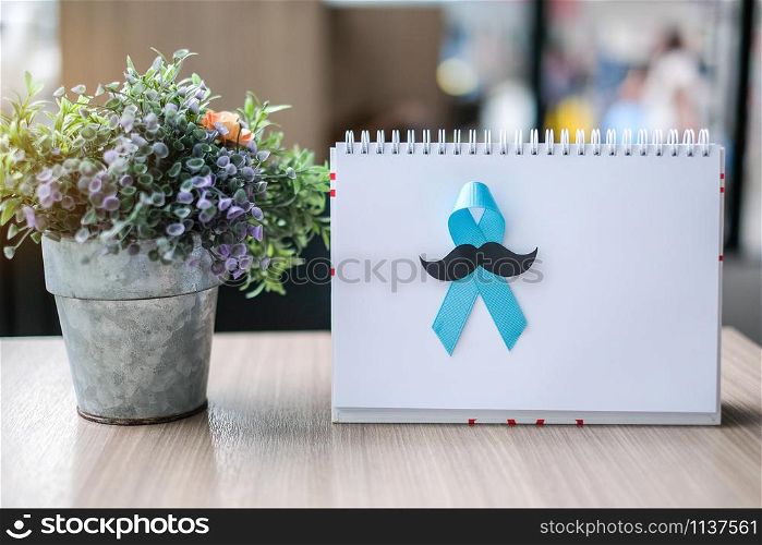 Prostate Cancer Awareness month (November), light Blue Ribbon on white paper for supporting people living and illness. Men Healthcare and World cancer day concept with copy space for your text