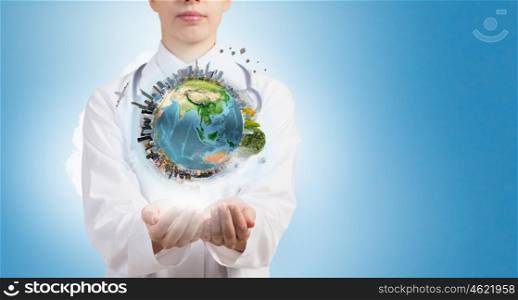 Protect life. Close up of female doctor holding Earth planet in hands. Elements of this image are furnished by NASA
