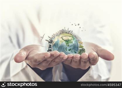 Protect life on Earth. Male hands holding world concept in palms. Elements of this image are furnished by NASA