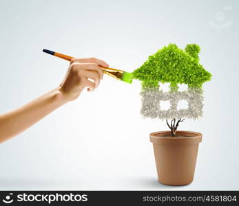 Protect our home. Close up image of hand painting plant shaped like house