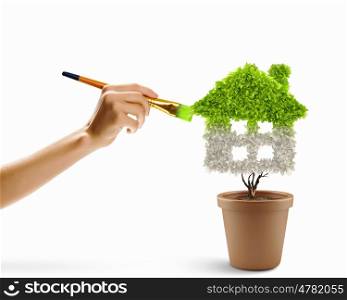 Protect our home. Close up image of hand painting plant shaped like house