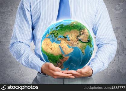 Protect our home. Close up of businessman holding Earth planet in palms. Elements of this image are furnished by NASA