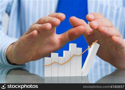 Protect your rising income. Hands of businessman covering rising growth graph
