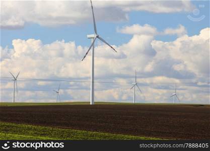 Protection of nature. Wind turbines eco power generator for renewable energy production. Alternative green clean energy, ecology. Cloudy sky meadow.