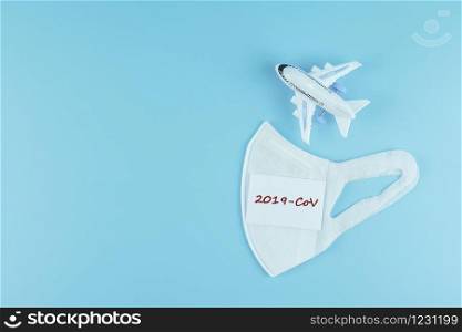 Protective face mask and airplane model on blue background, against Novel coronavirus (2019-nCoV) or Wuhan coronavirus and Influenza. Antiseptic, Hygiene and Healthcare concept