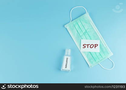 Protective face mask and sanitizer gel dispenser on blue background, against Novel coronavirus (2019-nCoV) or Wuhan coronavirus and Influenza. Antiseptic, Hygiene and Healthcare concept