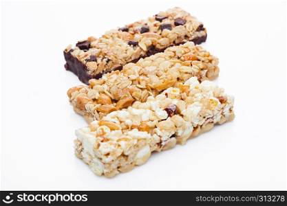 Protein cereal energy bars with nuts and caramel and chocolate for breakfast on white background