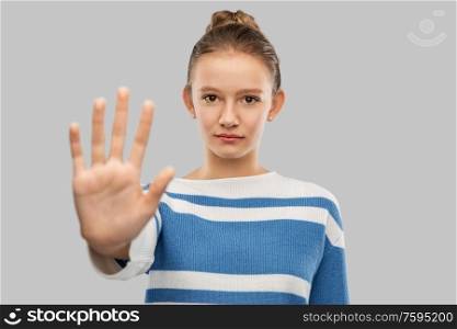 protest and people concept - teenage girl in checkered shirt making stopping gesture over grey background. teenage girl making stopping gesture