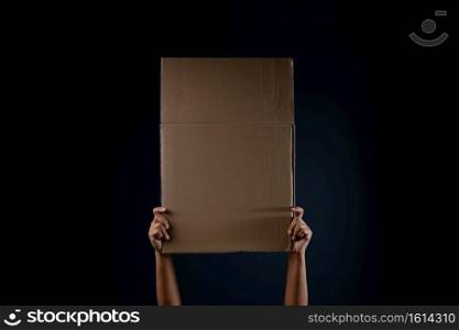 Protest , Mob or Expression Concept. Person Raised a Blank Corrugated Paper. Template Texture Background. Front View and Dark tone