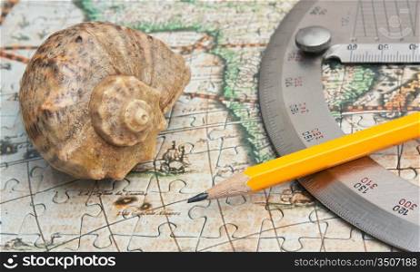 protractor and seashell on the map