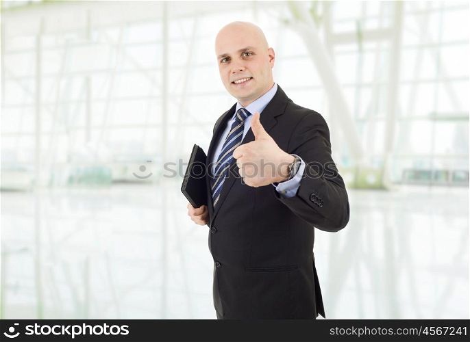 proud businessman with a tablet pc going thumb up, at the office